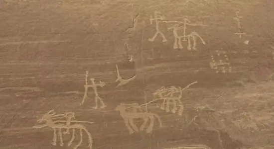 Ancient Egyptian rock art carvings depicting hunters and riders